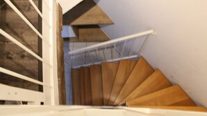Un escalier en bois avec une rampe blanche et un design moderne.