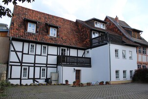 Ein traditionelles Fachwerkhäuschen mit steilem Dach, zahlreichen Fenstern und einem kleinen Balkon.