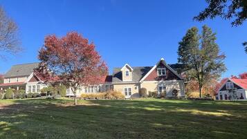 A row of houses with a well-maintained lawn and trees with autumn foliage.