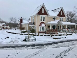Een groot, twee verdiepingen tellend huis met een opvallende veranda en schoorsteen.