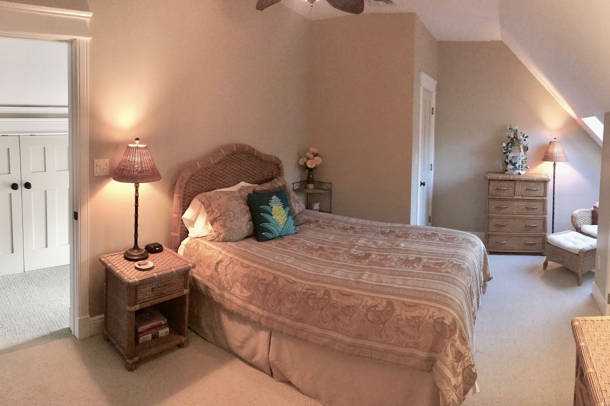 Een slaapkamer met een bed, nachtkastjes, een kaptafel en een stoel.