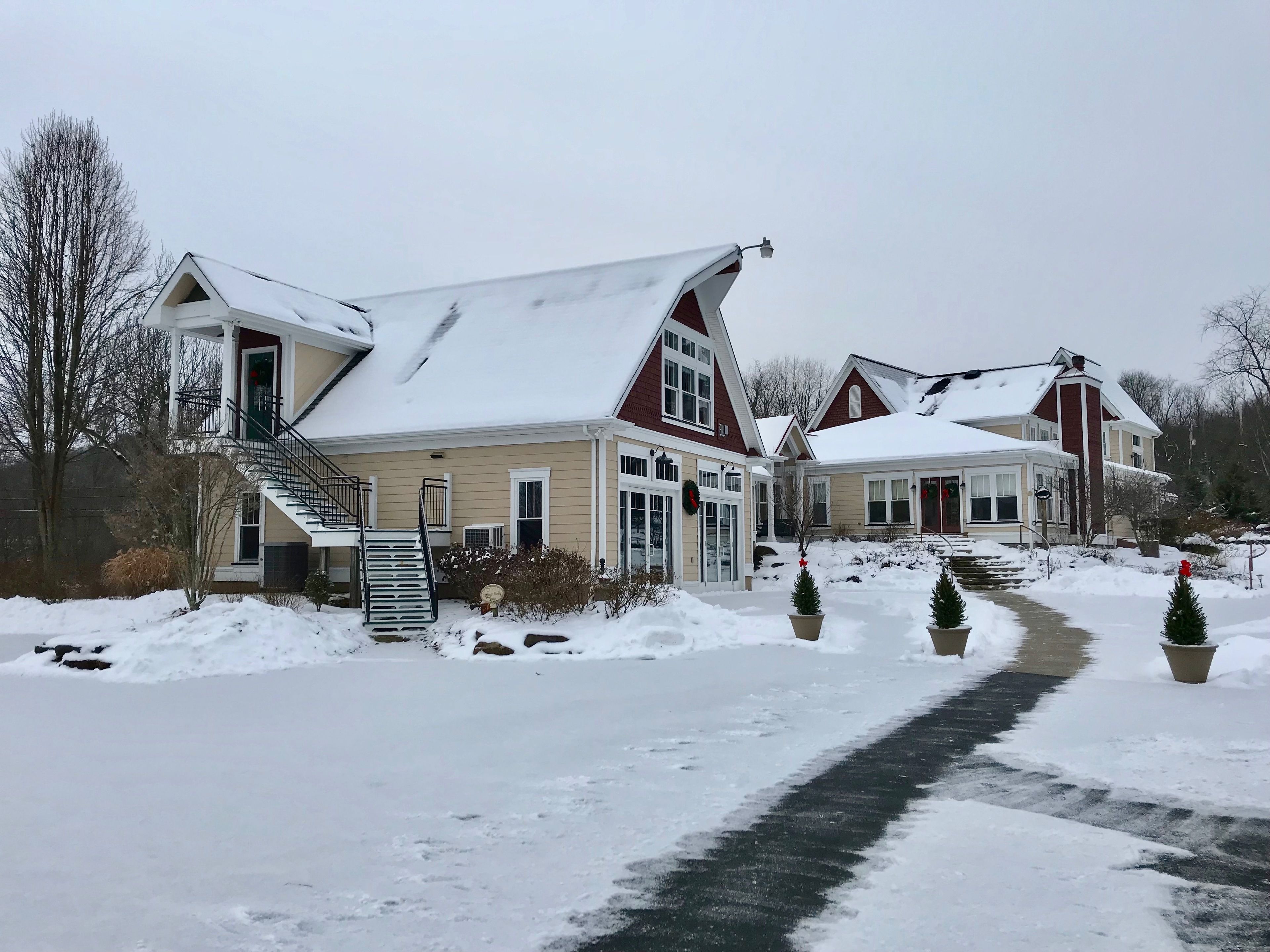 Et toetagers hus med et snedækket tag og en overdækket veranda.