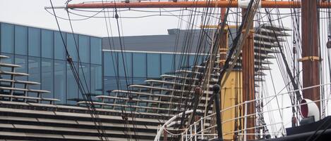 Arreglo de jarcia de barco y un edificio moderno al fondo.
