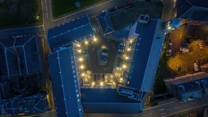 An aerial view of a parking lot with multiple rows of parked cars, surrounded by buildings. - Hotel Indigo Dundee by IHG (Dundee)