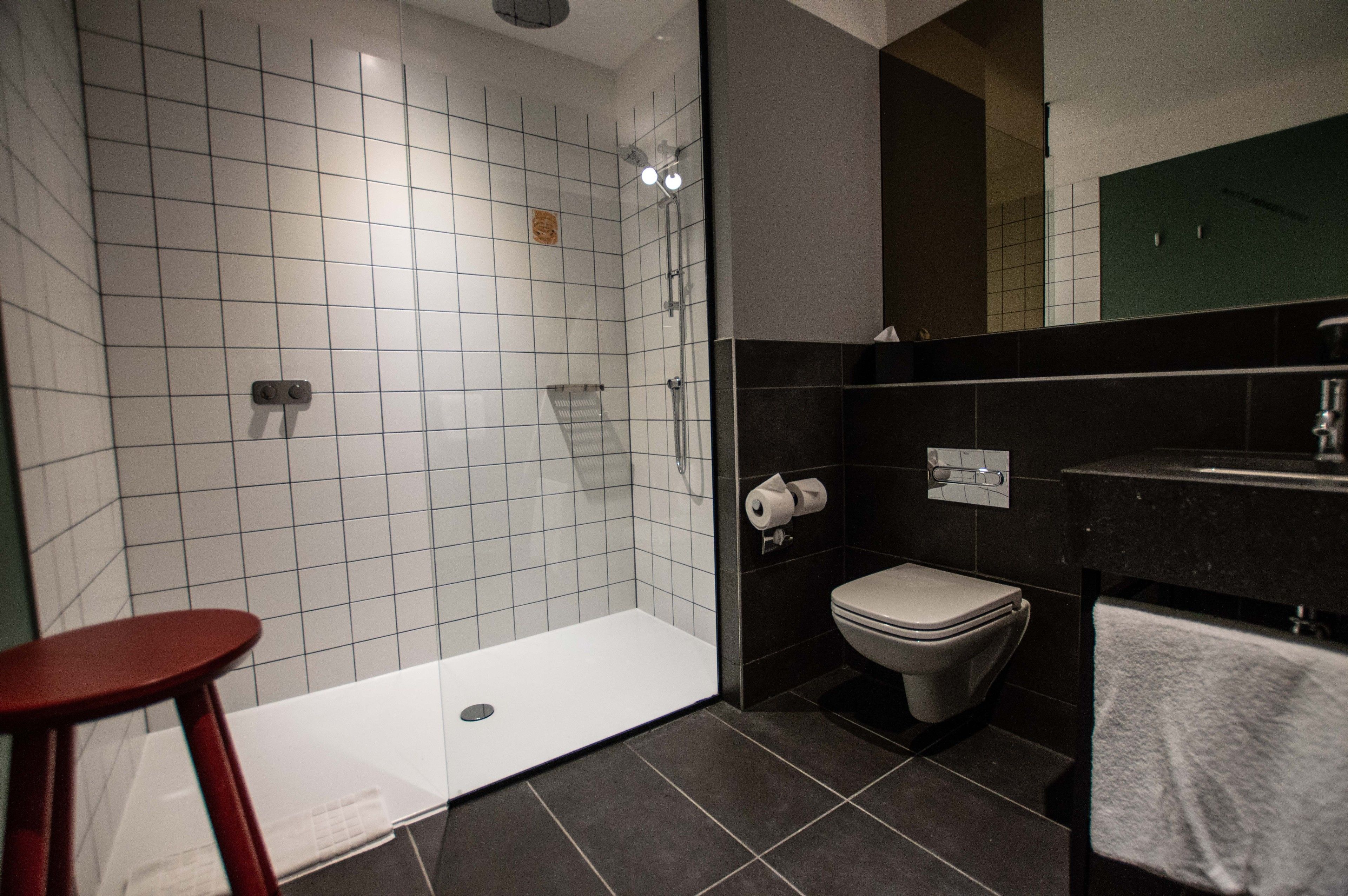 A bathroom with a shower, toilet, and sink.