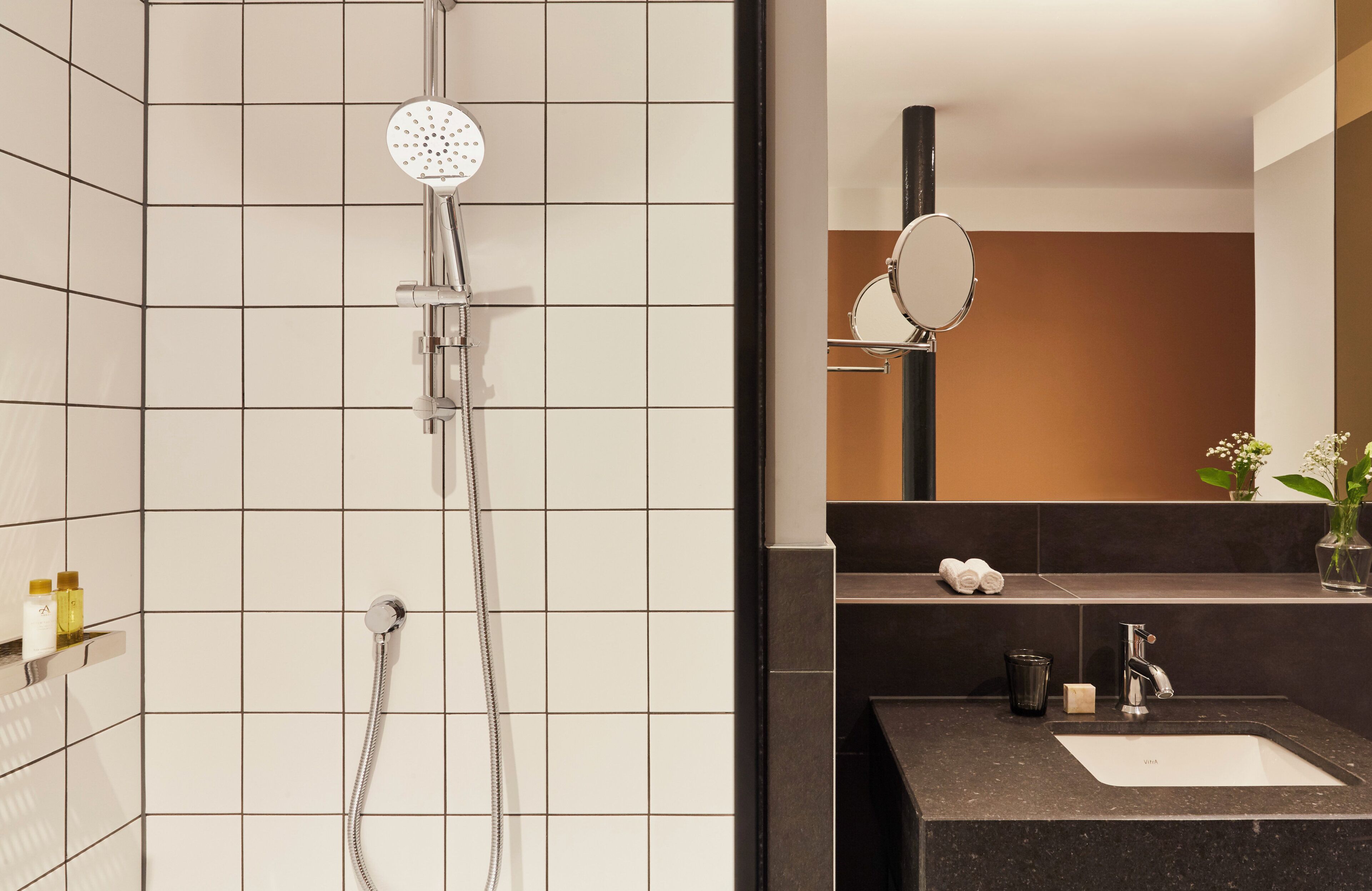 A bathroom with a shower, a sink, and a mirror.
