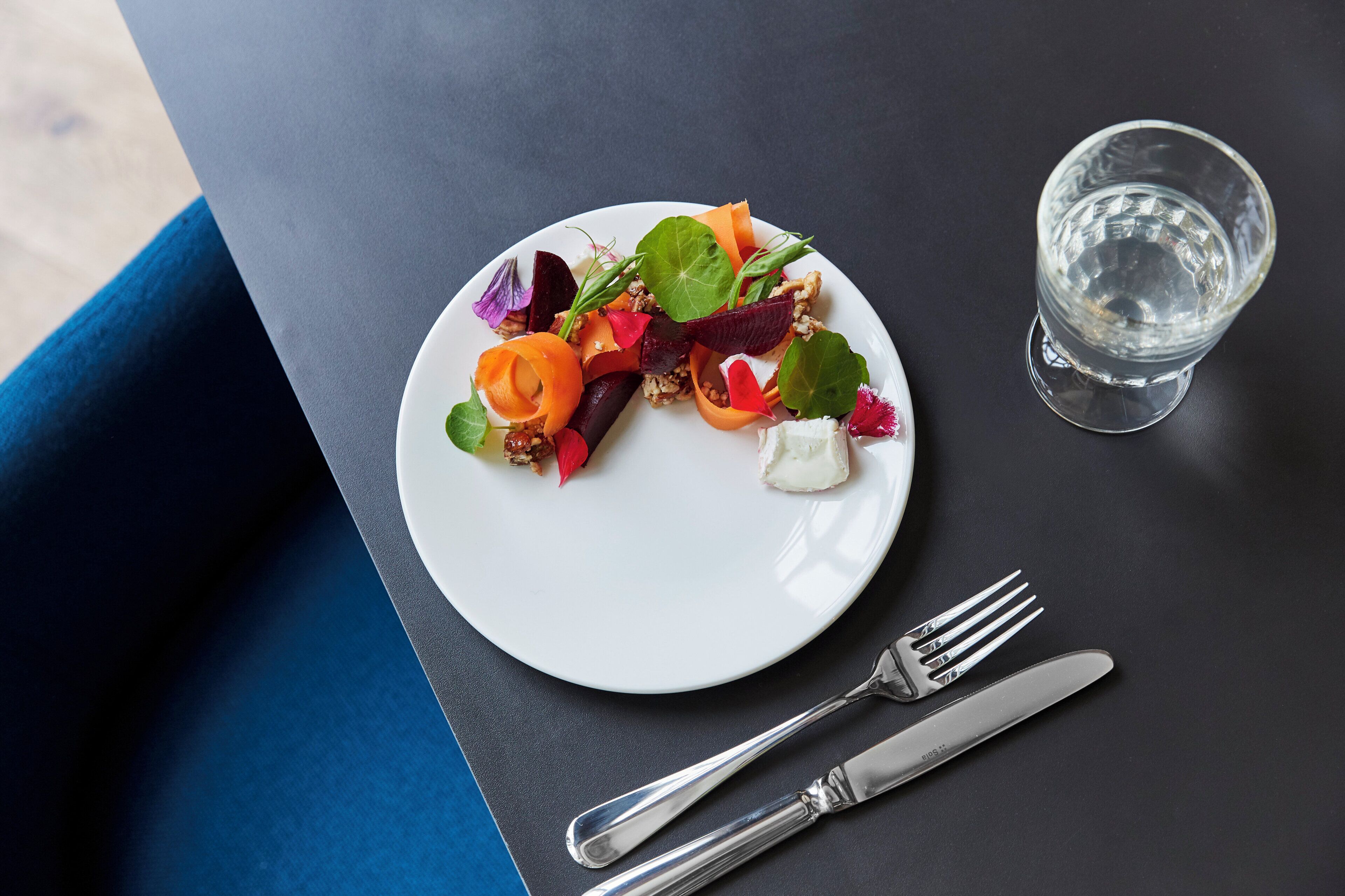 A plate of food with a fork and knife beside it on a table.