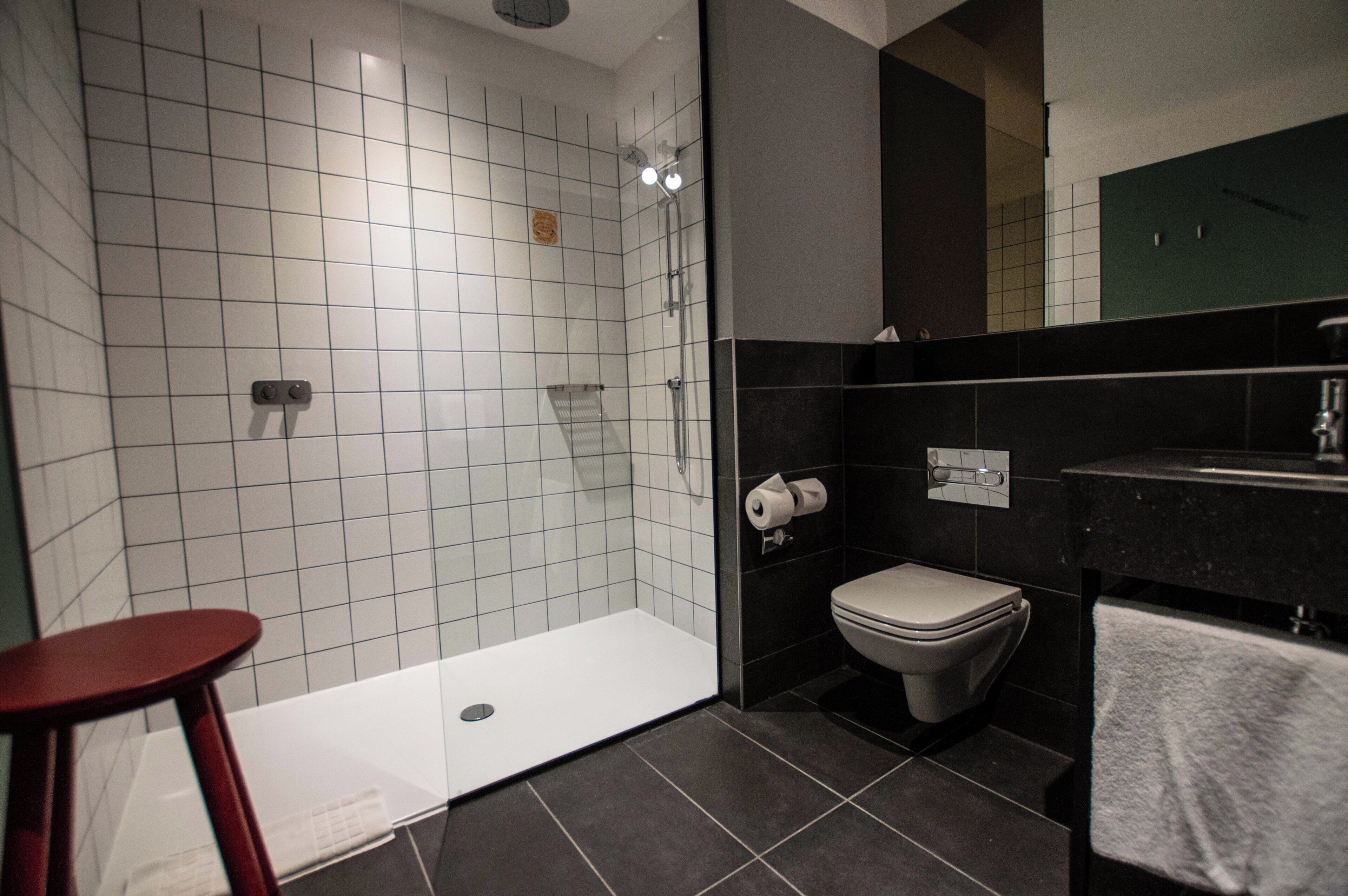 Un baño moderno con ducha, inodoro y lavabo.