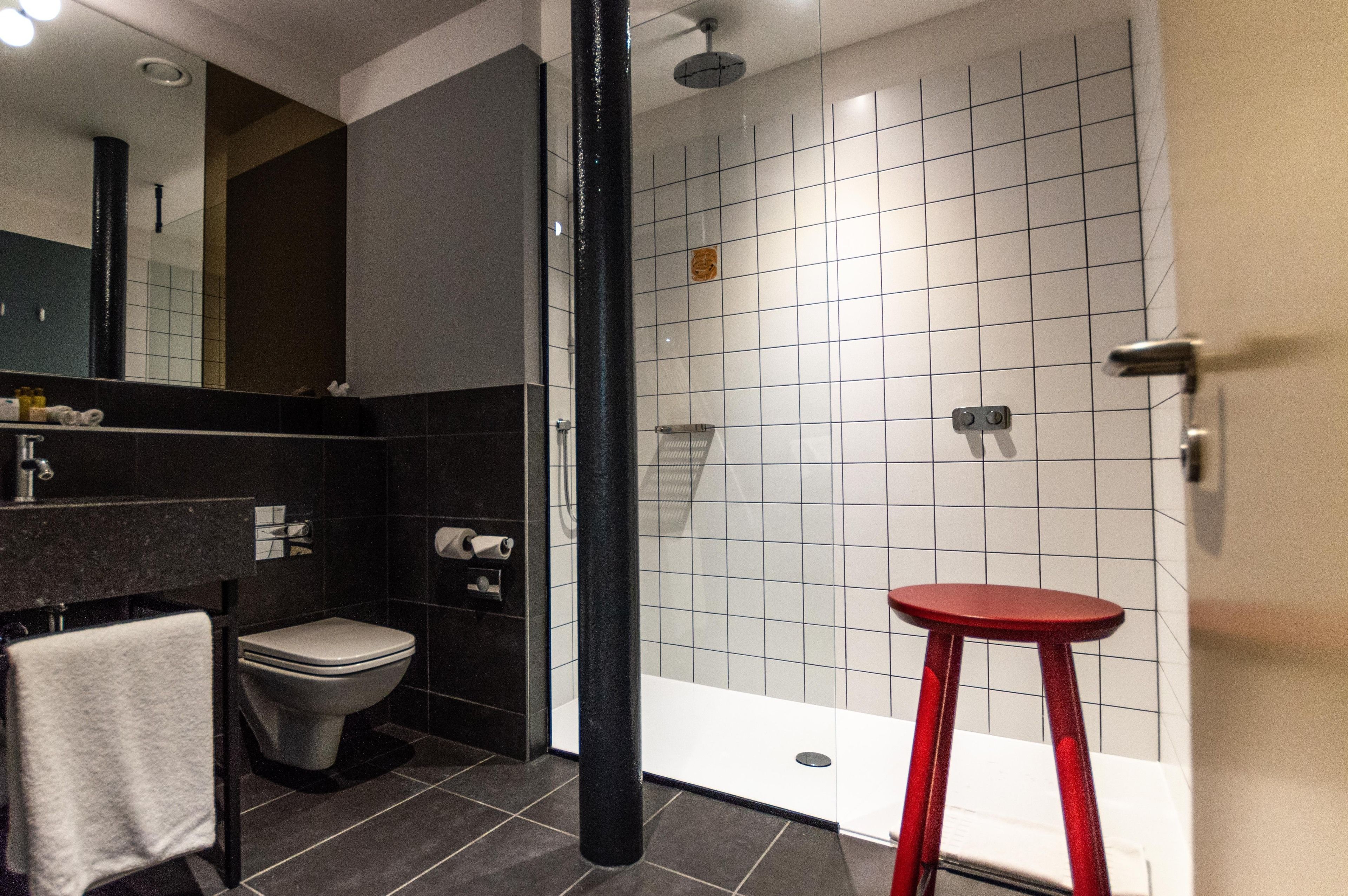 A modern bathroom with a toilet, sink, and shower area.