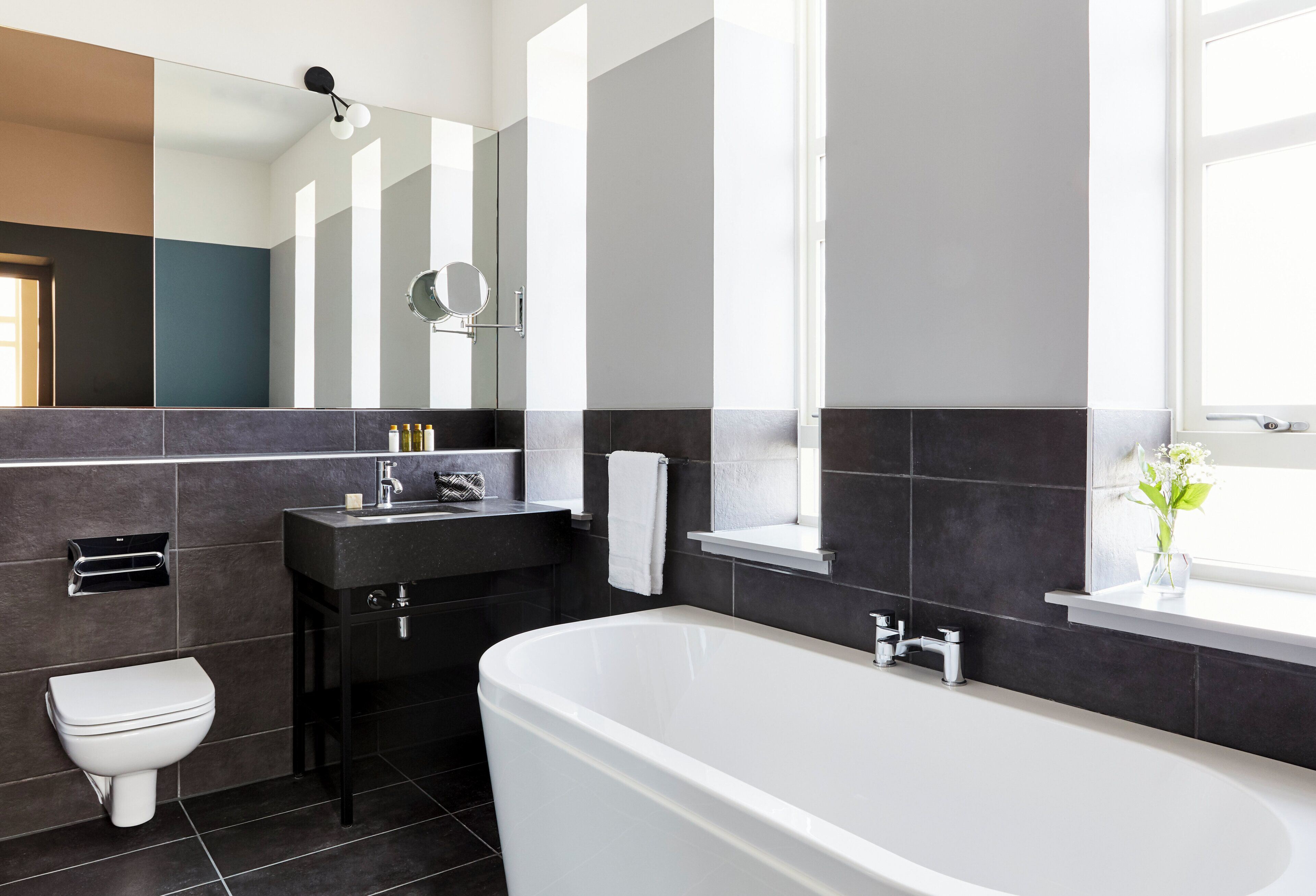 A modern bathroom with a bathtub, toilet, and sink.