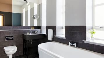A modern bathroom with a bathtub, toilet, and sink.