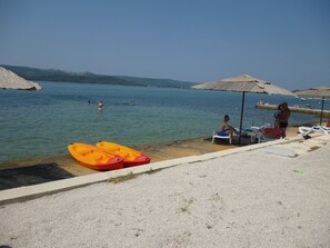 Na praia, barracas de praia de cortesia, espreguiçadeiras, guarda-sóis 