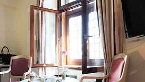 A hotel room with a round table, two chairs, a TV, and a window with curtains. - Malteser Komturei Hotel / Restaurant (Bergisch Gladbach)