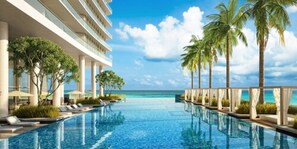 A swimming pool with a view of the ocean, palm trees, and a modern building with multiple floors. - Hyde Beach Condos by Ammos VR (Hollywood)