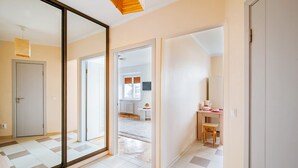 A spacious room with a large sliding glass door leading to a living area, a wooden desk, and a chair. - Apartments in Nemiga (Minsk)
