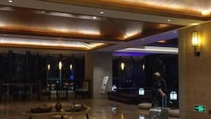 Un hall d’entrée moderne avec un sol en marbre, un espace détente avec des canapés et un comptoir d’accueil.