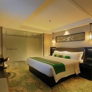 A hotel room with a bed, a desk, and a door. - Relaxed Season Hotel (Shenzhen)