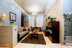 Relax in this stylish living room with a sofa, dining area, and central coffee table.