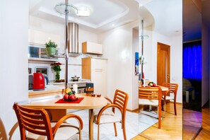 Enjoy meals in the kitchen and dining area, featuring a central island, stainless steel appliances, and a wooden table with four chairs.