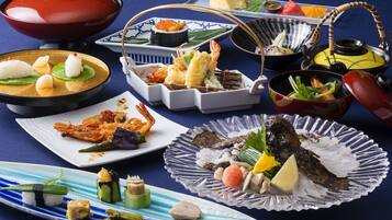 Verschiedene japanische Gerichte, darunter Sushi, Sashimi und Tempura, serviert auf traditionellem Porzellan und Glaswaren.