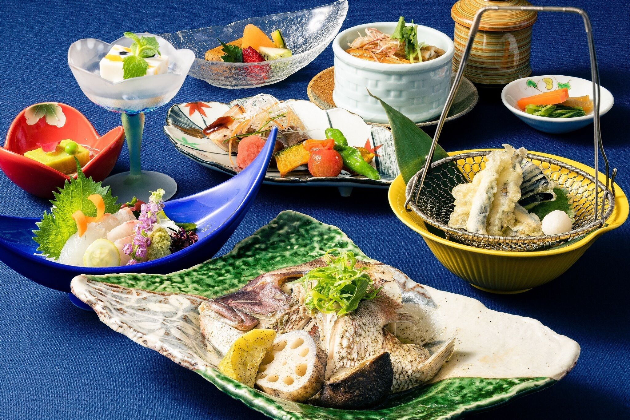 Diverse gerechten, waaronder sashimi, tempura en een kom rijst.