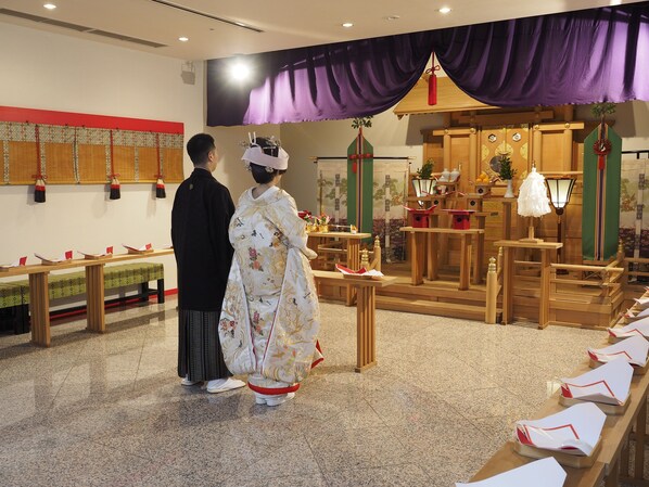 A traditional Japanese interior with tatami mats, wooden furniture, and a ceremonial altar.