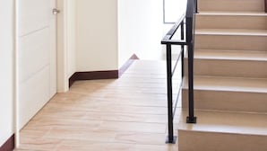 Un escalier avec une rampe noire menant à l’étage supérieur.