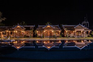A traditional building with a reflection in a pool, featuring multiple roofs and a central entrance. - Home Stone Resort (Battambang)
