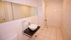 Une salle de bain avec un lavabo blanc, un miroir et une douche.
