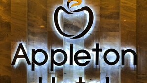 Neonbord voor Hotel Appleton met een gestileerd appel logo.