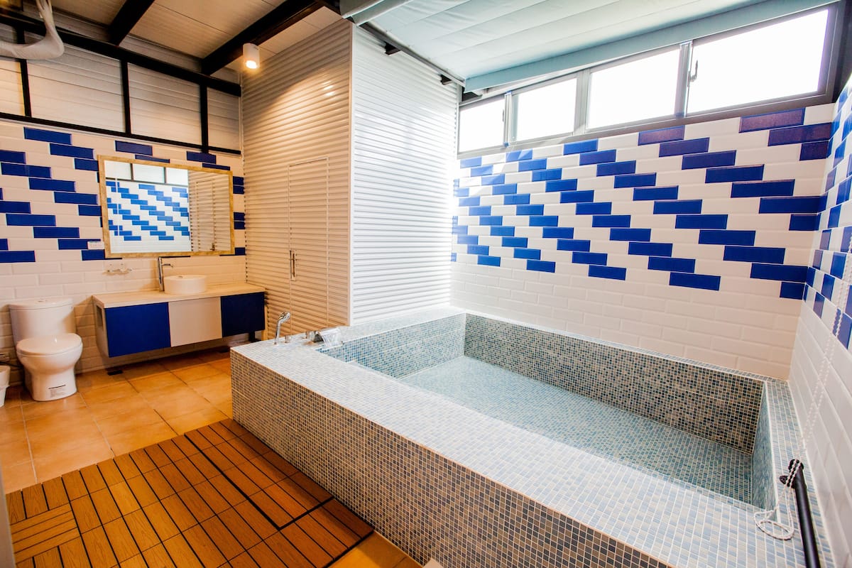 Un baño moderno con una bañera grande, un inodoro y un lavabo.