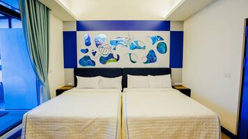 A double bed with a quilted duvet, a headboard with a blue and white abstract design, and a window with a curtain.