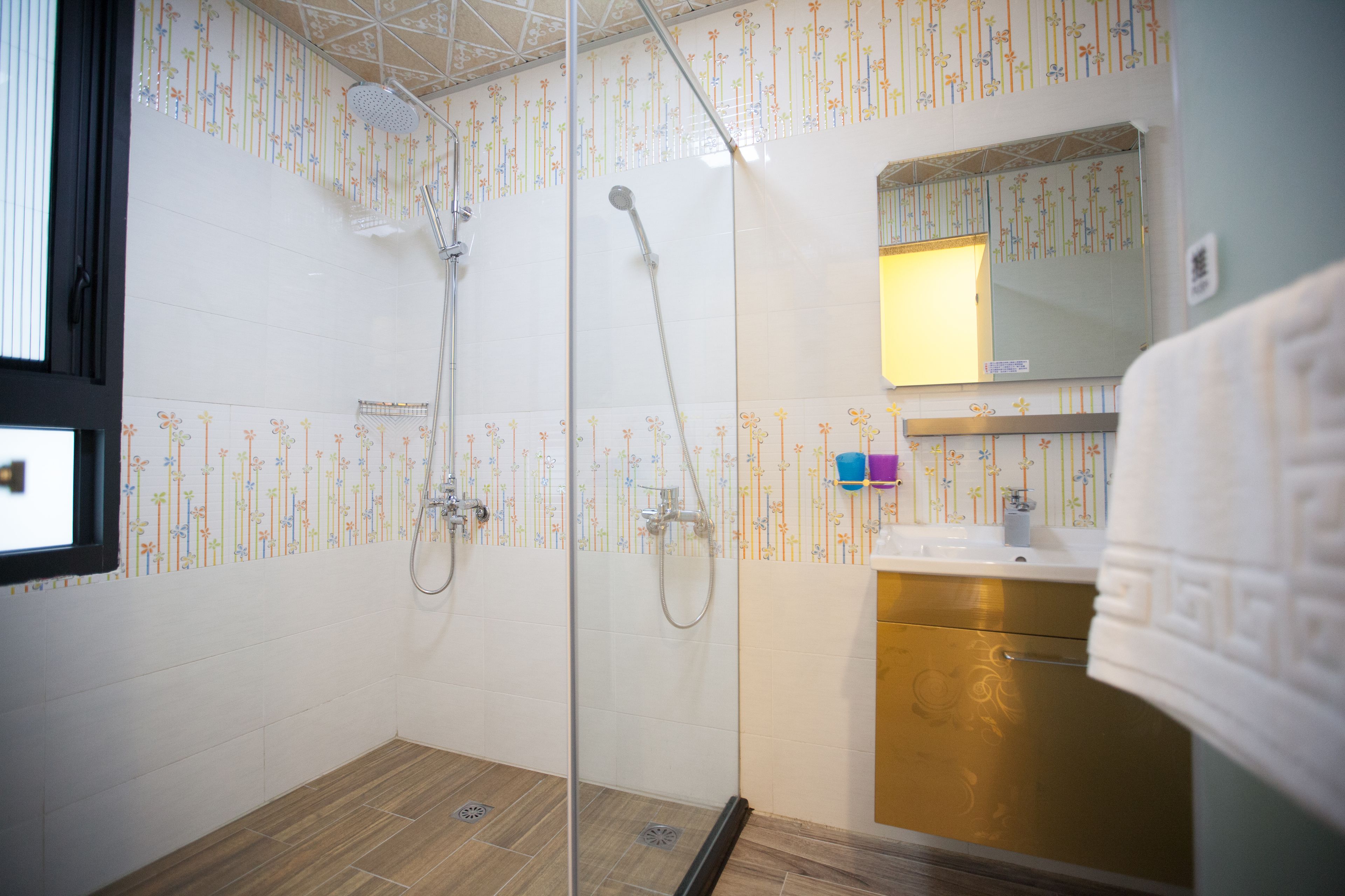 A bathroom with a shower, a sink, and a mirror.