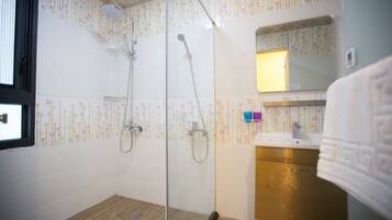 A bathroom with a shower, a sink, and a mirror.