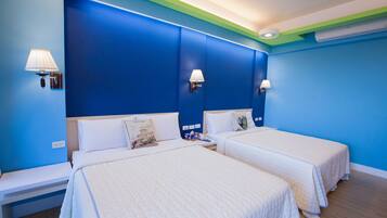 A hotel room with two beds, a nightstand, and a wall-mounted lamp.