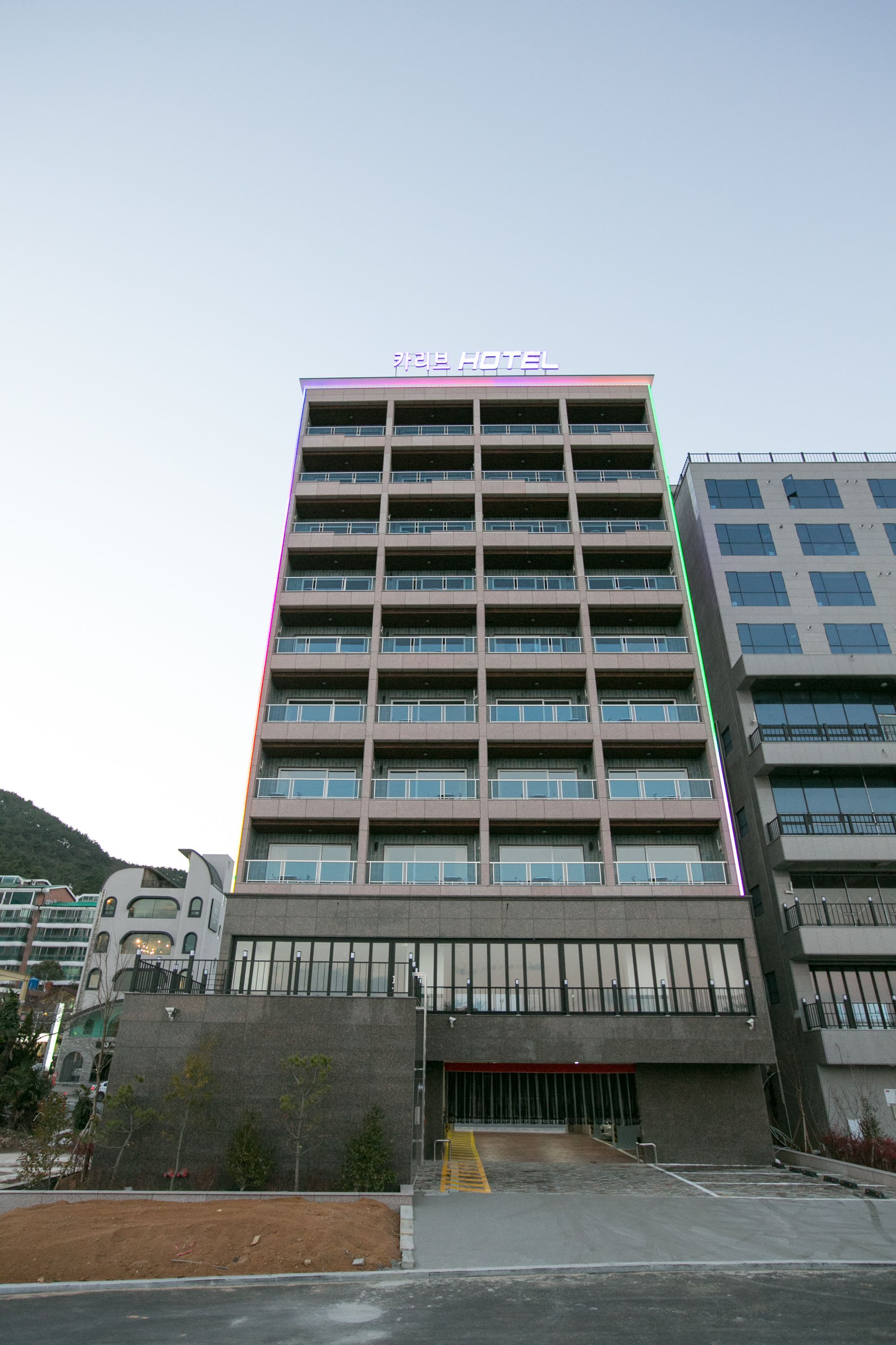 A multi-story hotel building with a modern design, featuring a prominent sign at the top.