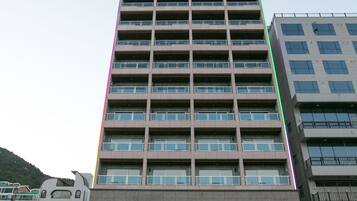A multi-story hotel building with a modern design, featuring a prominent sign at the top.