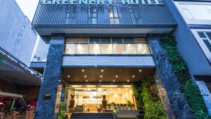 The exterior of the Greenery Hotel with a modern design, featuring a prominent entrance, a staircase leading to the lobby, and a facade with vertical greenery. - Greenery Hotel (Da Nang)