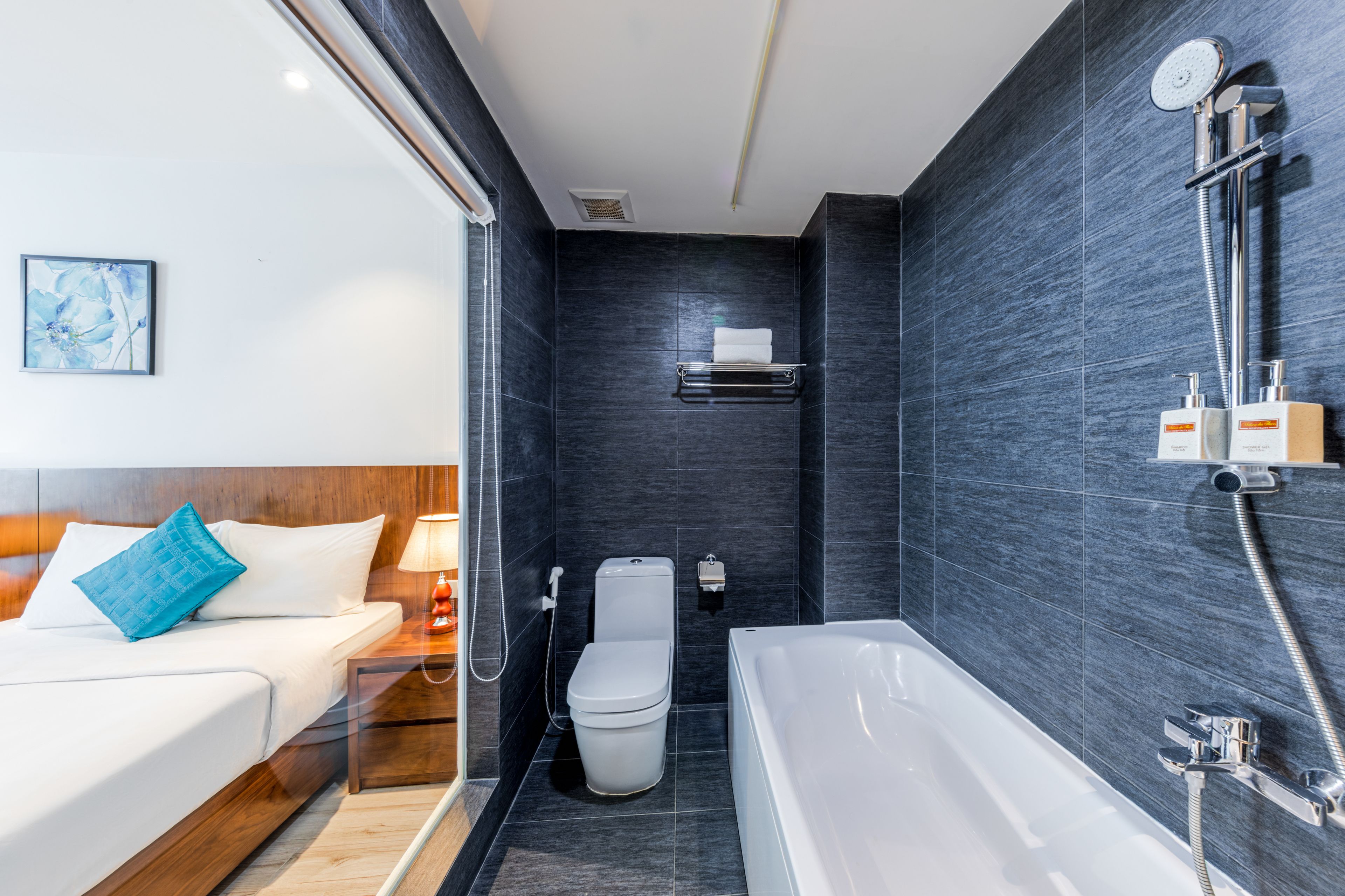 A modern bathroom with a bathtub, toilet, and shower.