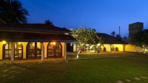 A two-story building with a covered patio area and a lawn in front. - Isle Of Thalpe (Unawatuna)