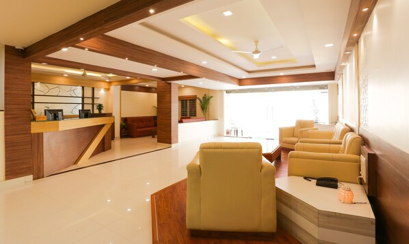 A hotel lobby with a reception desk, seating area, and a ceiling fan. - Itsy Hotels Worldtree Bellandur (Bengaluru)
