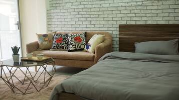 Un dormitorio con cama, sofá y una mesita de centro.