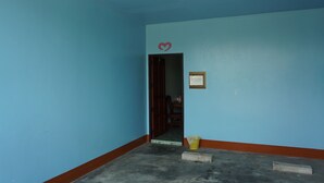 A room with blue walls, a heart-shaped decoration, a framed certificate, and a door leading to another room.