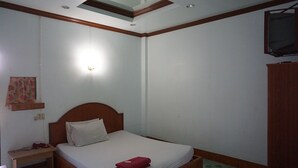 A bedroom with a single bed, a nightstand, a wall-mounted TV, and a ceiling light fixture.