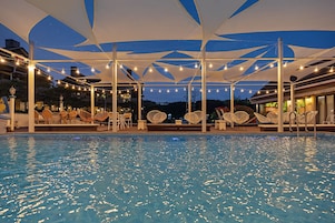 Una piscina al aire libre de temporada, sombrillas