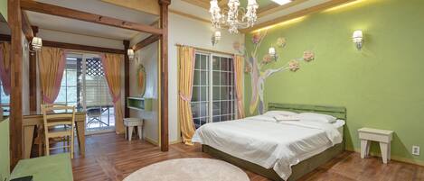A bedroom with a bed, a round rug, a desk, and a chair.