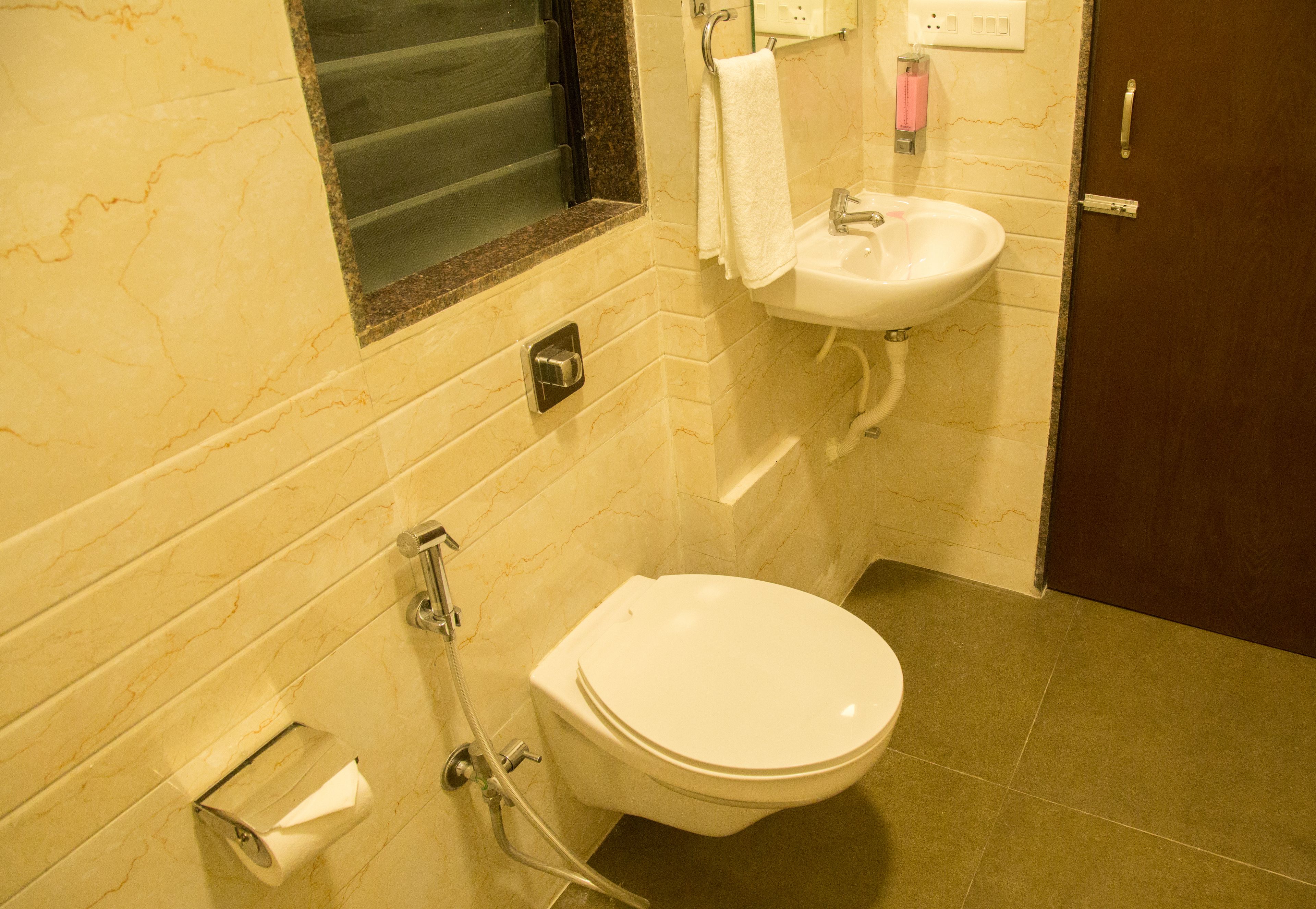 Een badkamer met toilet, wastafel en douche.