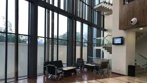 Tilava aula, jossa on suuret ikkunat, portaikko ja modernit istuimien sijoittelut.