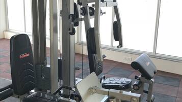 A gym with various exercise machines, including a Smith machine, a chest press, and a leg press.