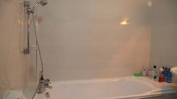 Een badkamer met een bad, een douche en een toilet.